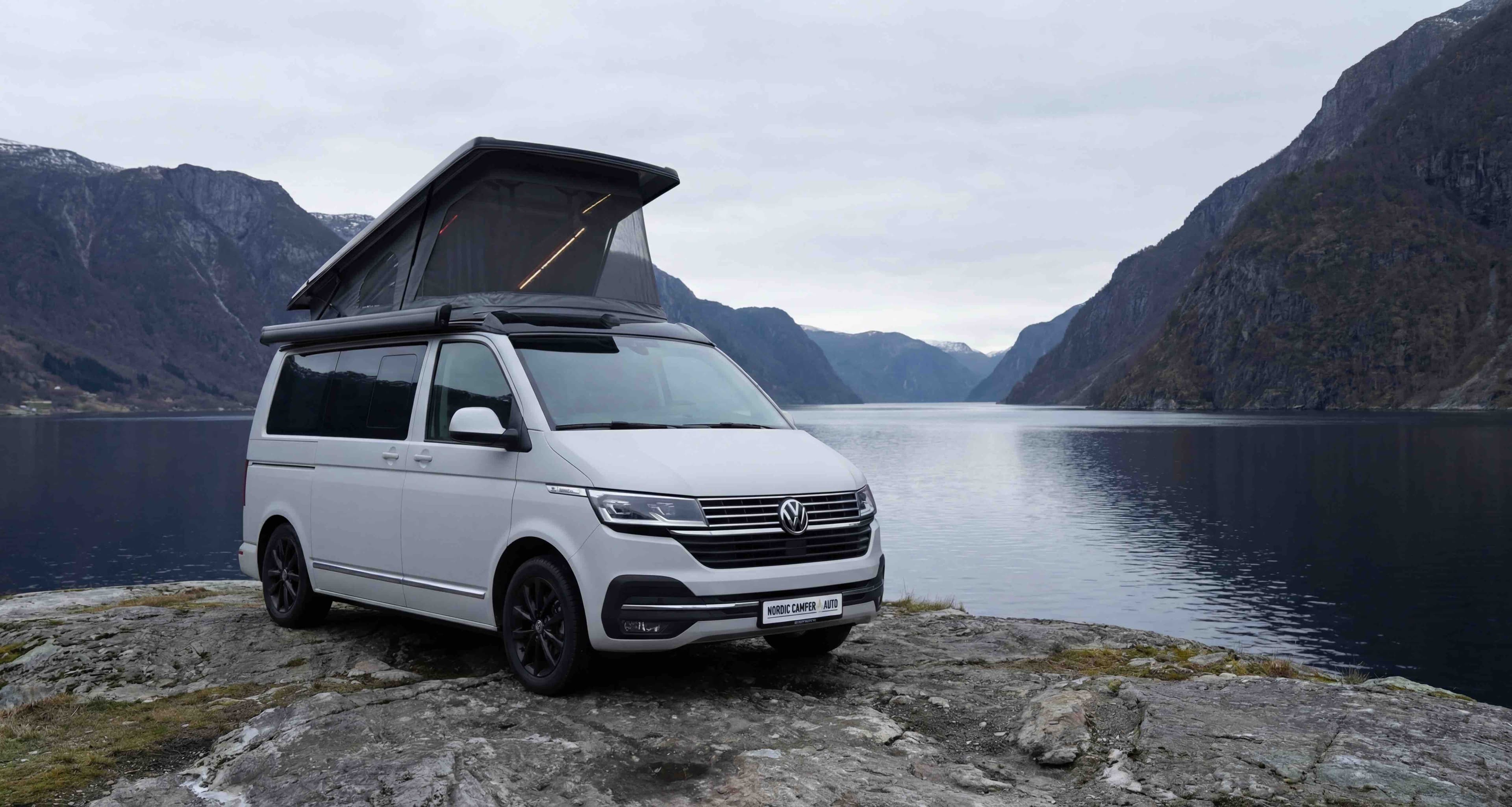 Custom camper van conversion by Nordic Camper & Auto parked by a Norwegian fjord with Scandinavian mountains